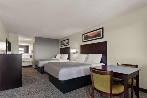 都柏林都柏林品质套房酒店的酒店客房设有两张床和一张桌子。
