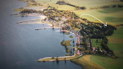 许尔斯霍斯特BEACHHOUSE VELUWEMEER in Strandnähe - mit extra großem Garten inkl Hallenbadnutzung的湖中一组岛屿的空中景观