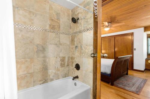 克拉克斯维尔Campbell Log Cabin! Historic Charm, Modern Luxury的带浴缸的浴室和卧室