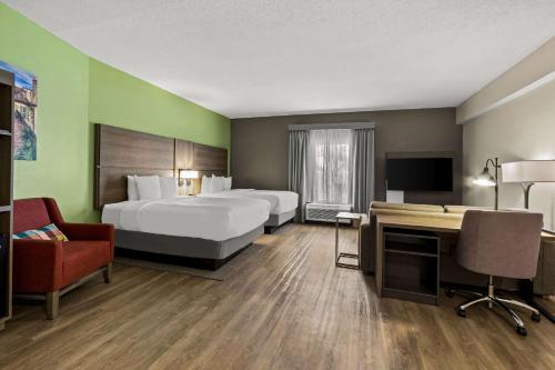 查尔斯顿Comfort Suites Charleston West Ashley的酒店客房配有两张床和一张书桌