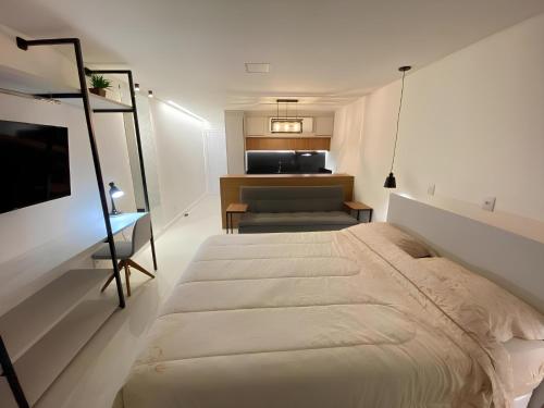 波梅罗迪Flat Home Business 202 Centro Pomerode的一间白色卧室,配有床和厨房