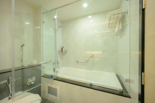 南芭堤雅Lewit Hotel Pattaya, a member of Radisson Individuals的一间带玻璃淋浴和卫生间的浴室