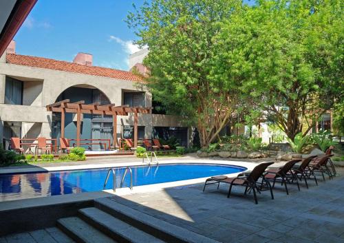 圣何塞哥斯达黎加圣何塞丽笙酒店的房屋旁带椅子的游泳池