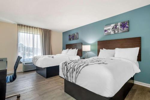 纽波特纽斯Sleep Inn & Suites的酒店客房设有两张床和窗户。
