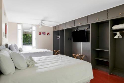 莫比尔Midcentury Modern - Pool & Hot tub - Retro Retreat的一间卧室配有两张床和一台平面电视
