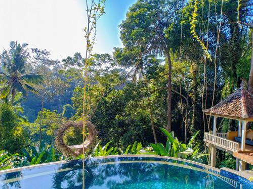 乌布Made Punias Jungle Paradise的一个带凉亭和树木的度假游泳池