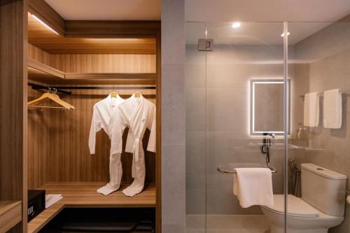 雪邦Holiday Inn Sepang - Airport的一间带卫生间和玻璃淋浴间的浴室