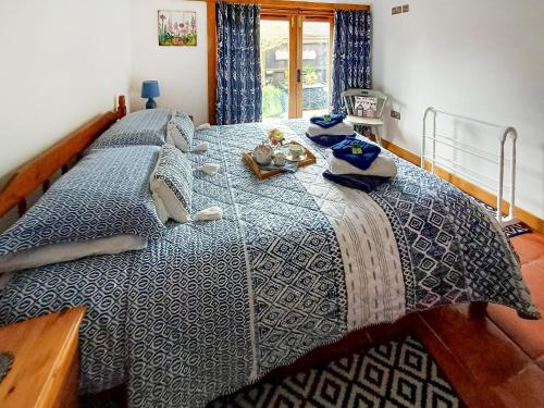伍尔Meadow Barn的一间卧室配有一张带蓝色棉被的大床