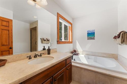 玛瑙湾Tahoe Haven的浴室配有盥洗盆和浴缸。