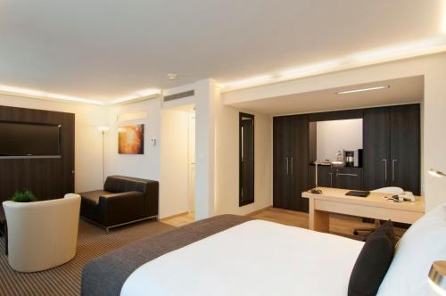 苏黎世Crowne Plaza Zürich, an IHG Hotel的配有一张床和一张书桌的酒店客房