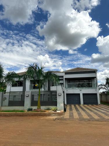 哈拉雷holiday villa的前面有棕榈树的房子