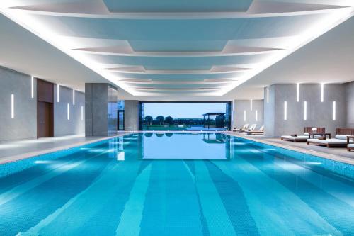 Shunde顺德保利假日酒店的大楼内一个蓝色的大型游泳池