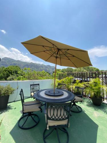 迪坡斯特兰Posada Vista Tepoz的庭院内桌椅和遮阳伞