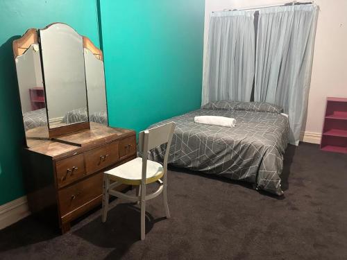 South RakaiaRailway Hotel的一间卧室配有一张床、梳妆台和镜子