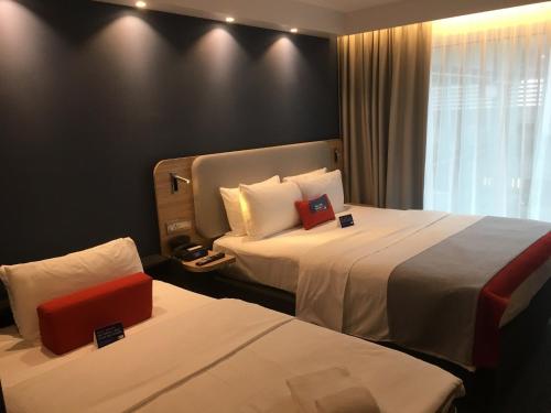 吕姆朗Holiday Inn Express Zürich Airport, an IHG Hotel的酒店客房设有两张床和窗户。