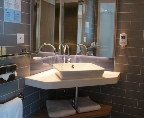 吕姆朗Holiday Inn Express Zürich Airport, an IHG Hotel的浴室设有白色水槽和镜子