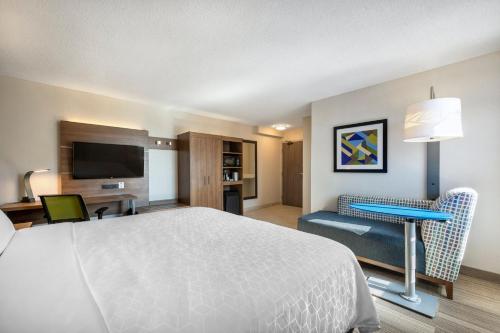 多伦多多伦多市中心快捷假日酒店的酒店客房设有一张床、一张书桌和一台电视机。