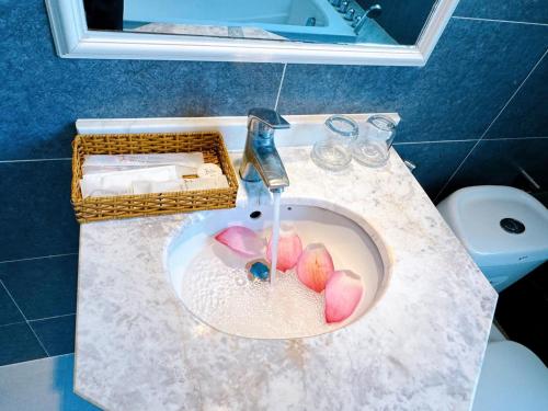 胡志明市Aodai Inn Saigon的浴室水槽从水龙头流出水