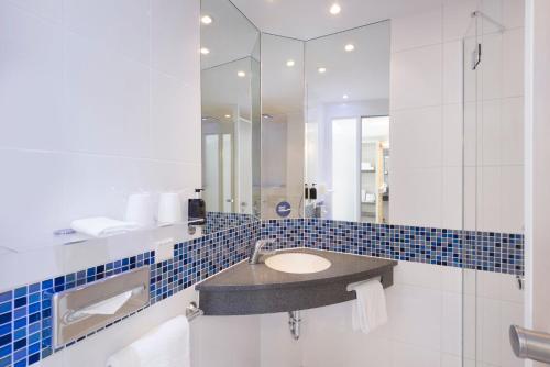 辛根辛根快捷假日酒店的一间带水槽和镜子的浴室