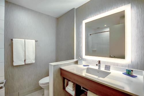 卡尔加里Holiday Inn Express & Suites - Calgary Airport Trail NE, an IHG Hotel的一间带水槽、卫生间和镜子的浴室
