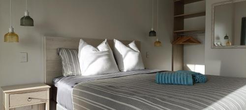 但尼丁Luxurious waterfront accommodation的卧室配有带白色枕头的大床