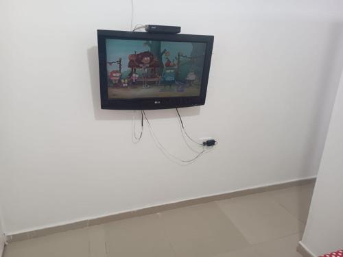 巴耶杜帕尔APTO AMOBLADO CERCA A PLAZA ALFONSO LOPEZ的客房内白色墙壁上的电视