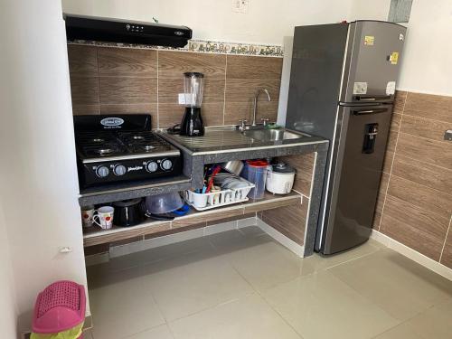 巴耶杜帕尔APTO AMOBLADO CERCA A PLAZA ALFONSO LOPEZ的厨房配有炉灶、水槽和冰箱。