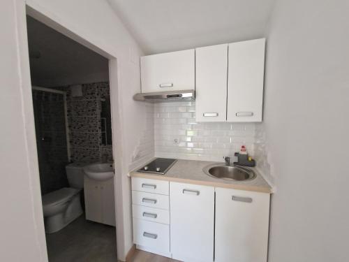 乌马格Rooms Lav的白色的厨房设有水槽和卫生间