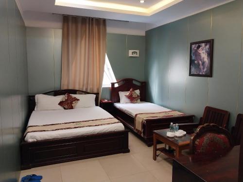 Tây Ninh那克酒店的酒店客房设有两张床和一张桌子。