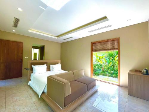 Ninh HòaBaHo Eco Beat的一间卧室配有一张床、一张沙发和一个窗口