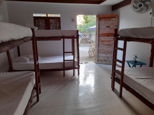 巴尔Hostal El Nido del Azulejo的带三张双层床和门廊的客房