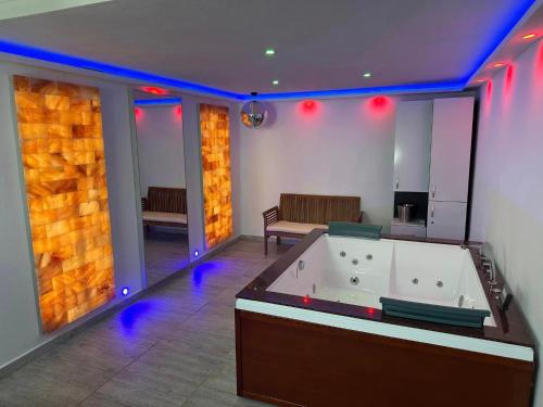 锡比乌Casa Hanea & SPA piscina exterioara incalzita ,sauna, jacuzzi privat in fiecare apartament的大型客房设有带紫色灯的浴缸。