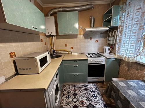 阿拉木图Apartment on Akhmetova 10的一间小厨房,配有绿色的橱柜和微波炉