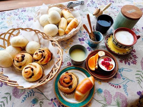 Nukabiraペンション 旅とPizzaとお宿 咲色-Sairo-的一张桌子,上面放着一篮子的糕点和面包