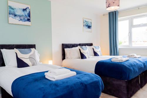 托顿Relaxing 4 Bedroom Retreat For Long Stays Fawley的蓝色和白色的客房内的两张床