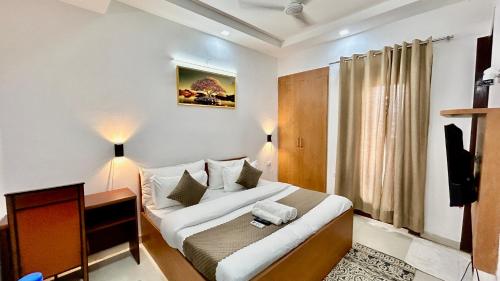 古尔冈Aura Luxury Studio Near Golf Course Road, Sector 57, Gurgaon的一间卧室配有一张床、一张书桌和一台电视