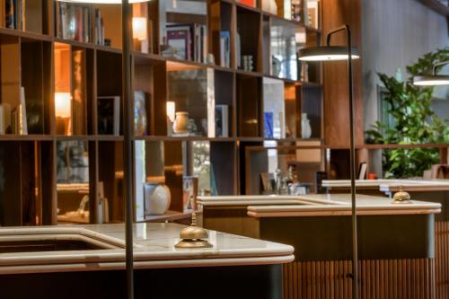 马德里库斯科万豪AC酒店的一间图书馆,里面设有书架和桌子