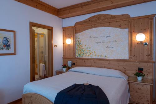 马洛斯科Hotel Bel Soggiorno的一间卧室设有一张大床和一个大墙