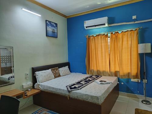 布巴内什瓦尔Hotel GD Stay Inn Near Mahura Chhak的一间卧室设有一张床和蓝色的墙壁