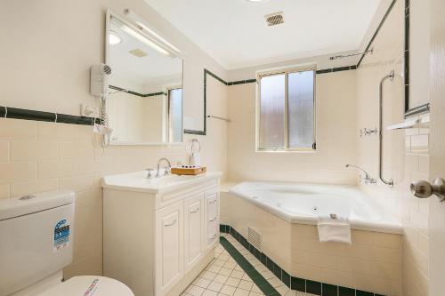 凯阿玛特雷隆阳台公寓的带浴缸、盥洗盆和卫生间的浴室