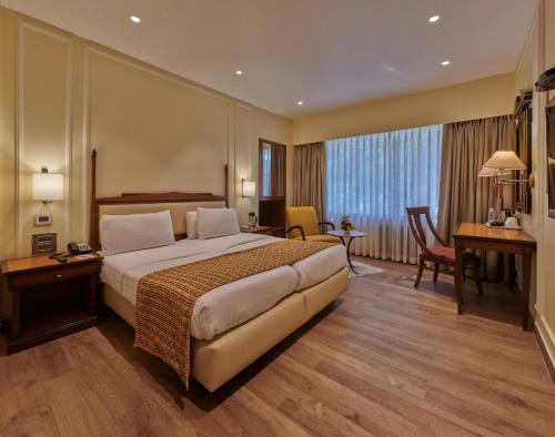 孟买Hotel Residency Andheri的配有一张床和一张书桌的酒店客房