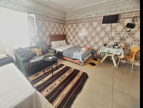阿加迪尔Moschea di Agadir的一间卧室配有一张床、一张沙发和一张桌子