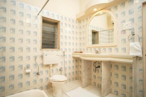巴夫那加尔Nilambag Palace Hotel的一间带卫生间、水槽和镜子的浴室