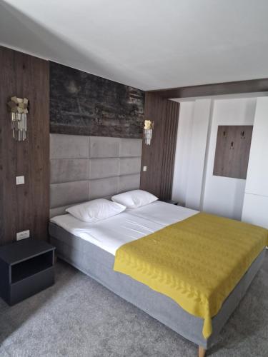 加拉茨Hotel City Break的一间卧室配有一张带黄色毯子的大床