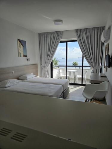 拉纳卡Les Palmiers Sunorama Beach Apartments的酒店客房设有两张床和一个阳台。