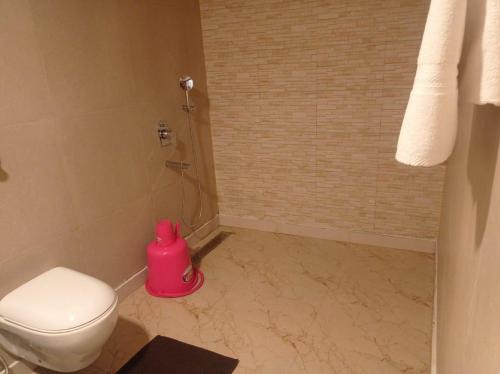 KhawāsaThe Palash Vann Pench的浴室位于厕所旁,配有粉红色的容器