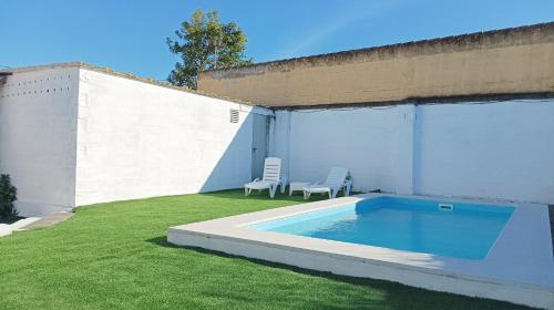奇克拉纳－德拉弗龙特拉Casa de campo con piscina的庭院里的小游泳池,带两把椅子