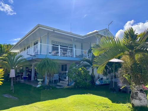 法勒Meri Lodge Huahine « ROOM OF MARTA »的带阳台和棕榈树的大型白色房屋