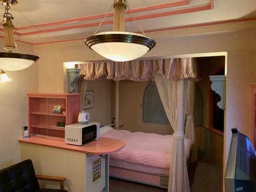 Iwakiriホテル　プレリュード的一间卧室配有一张床和一张带微波炉的桌子。