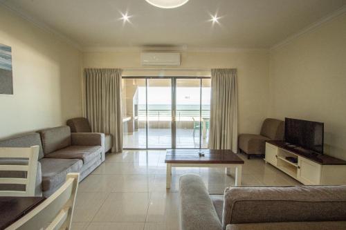 乌旺戈海滩Saints View Resort Unit 16的带沙发、电视和桌子的客厅